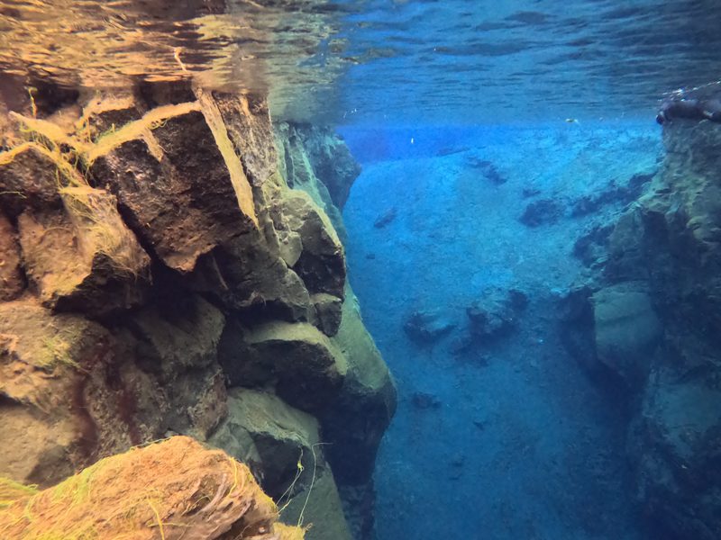 Layered lava rock formations along the edge of the Silfra fissure