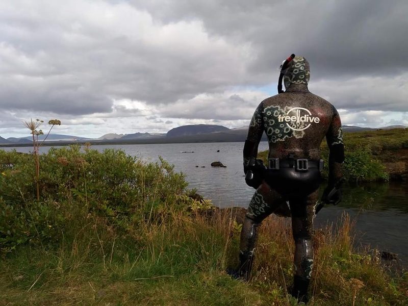 A diver in a Freedive Iceland wetsuit looking out over Þingvellir National Park