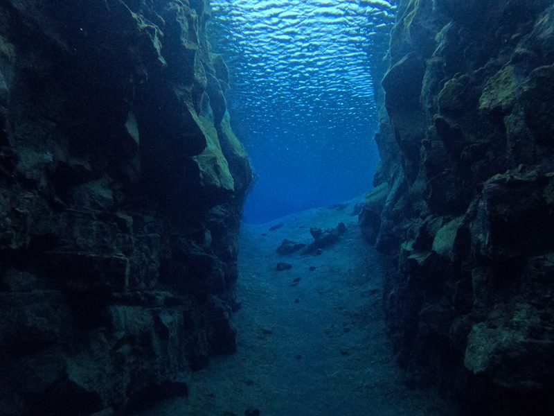 A sandy channel between two rock walls inside the Silfra fissure